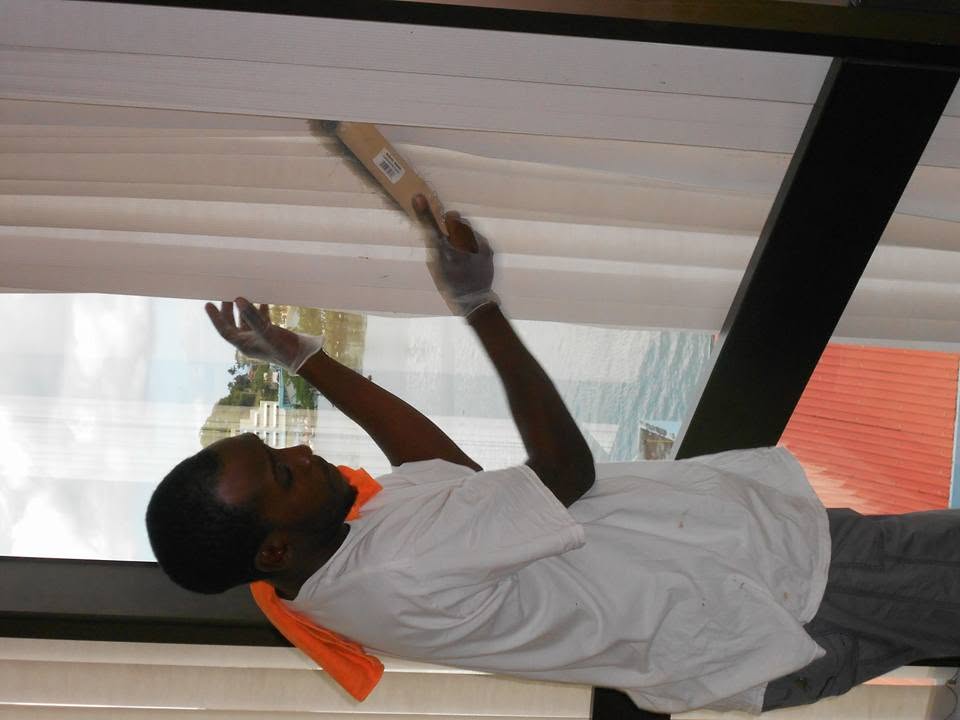 Technician scrubbing an office window frame in St. Lucia