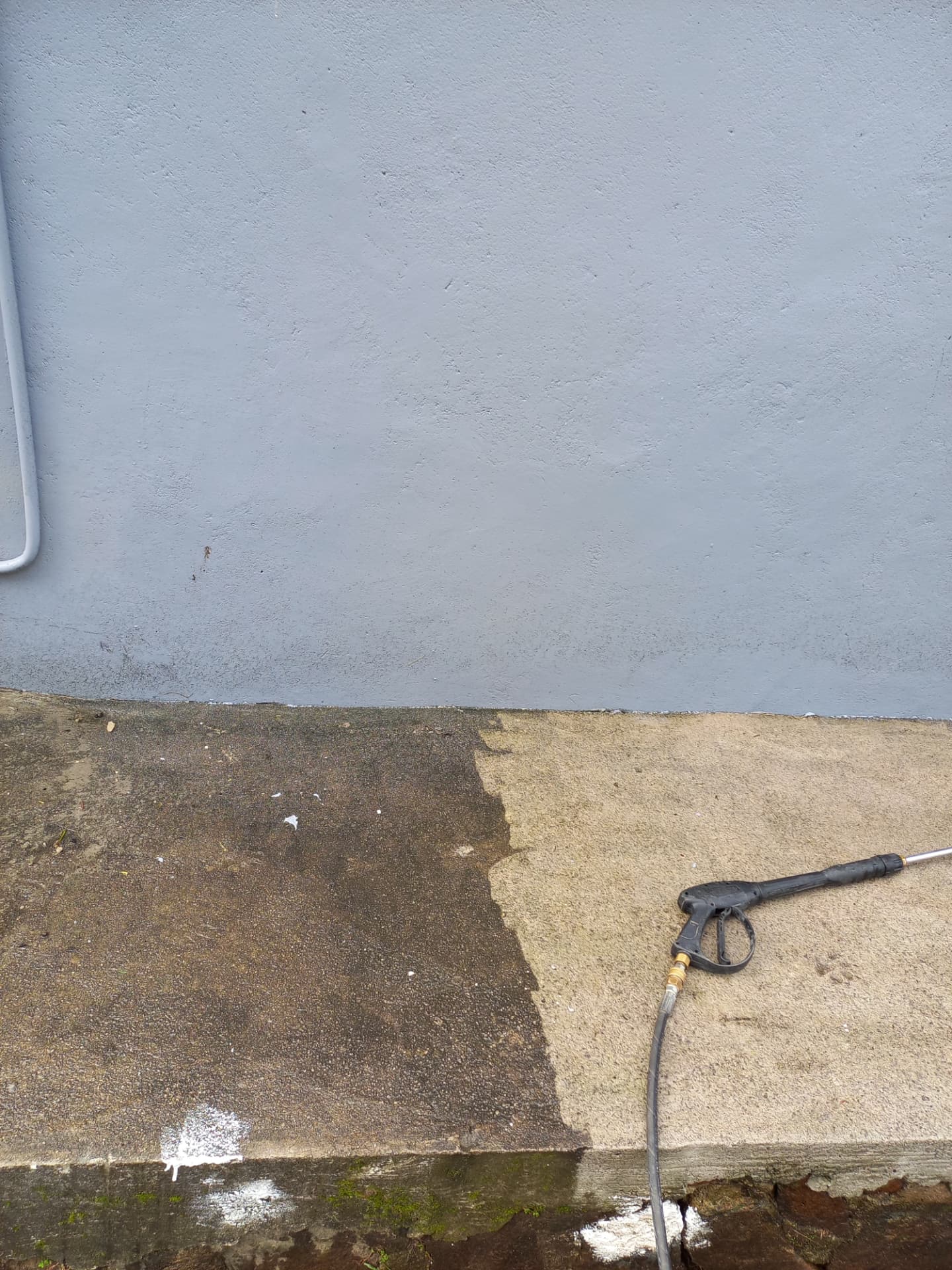 Pressure washing concrete showing cleaned surface